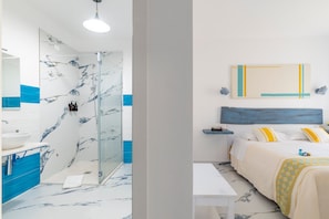 A modern bathroom with a glass shower, a sink, and a marble floor.