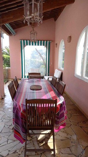 Un espace repas comprenant une grande table, des chaises et une vue par la fenêtre.