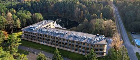 A large building with multiple parking spaces and a road running alongside it.