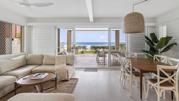 A modern living room with a sofa, coffee table, and dining area. - Thirty-Nine Albatross (Apartment 3) (Mermaid Beach)