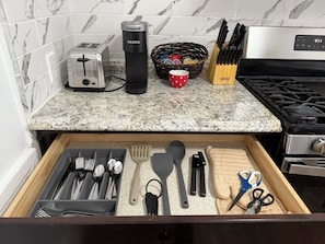 A kitchen counter with a toaster, a Keurig coffee maker, a basket of tea bags, a red mug, and a knife block. - Comfy 3BR/1.5B 2 Fl Apt in Bryn Mawr -Parking (Bryn Mawr)