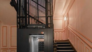 Eine Treppe mit schwarzer Metallreling, die zu einer unteren Ebene führt.