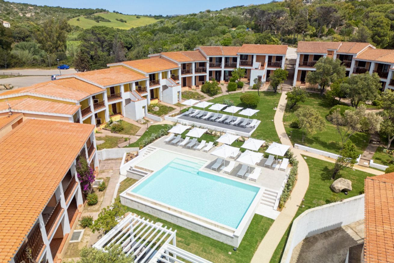 Un complexe hôtelier comprenant plusieurs bâtiments, une piscine et des espaces de détente en plein air.
