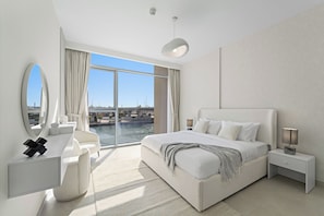 Una camera d'albergo moderna con un letto grande, una scrivania, una sedia e vista sulla città attraverso ampie finestre.