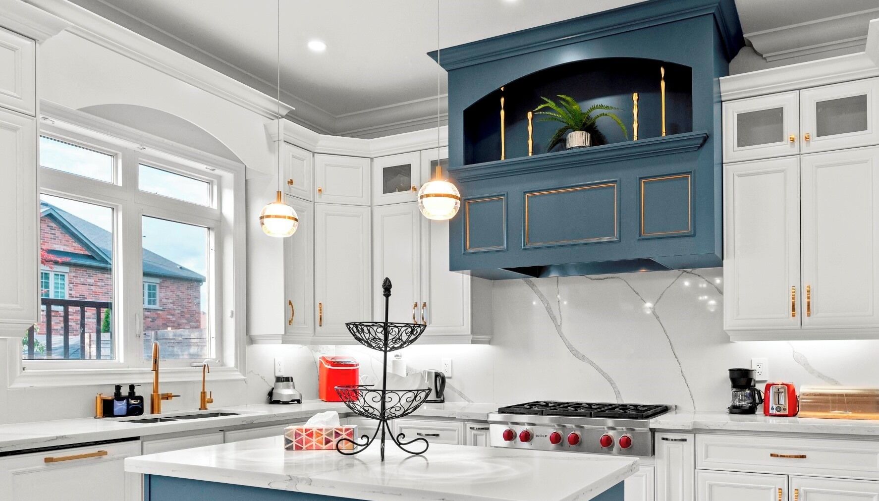 A modern kitchen with white cabinetry, a central island, and a blue accent wall.