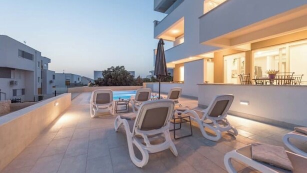 Une terrasse sur le toit avec des sièges extérieurs et une piscine.