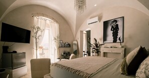 A bedroom with a bed, a TV, a desk, and a chair. - Da Leah - Ragusa Design Stay (Ragusa)