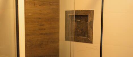 A bathroom with a wooden vanity, a mirror, a towel, and a toilet paper roll.