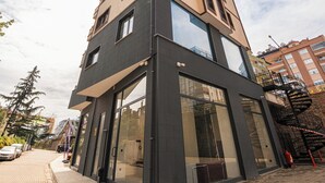 A multi-story building with a modern architectural design, featuring large windows and a mix of glass and dark facade materials. - Servi House (Akçaabat)