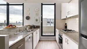 Una cucina moderna con un'ampia finestra, elettrodomestici in acciaio inossidabile e vista sulla città.