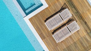 An aerial view of a pool area with wooden decking and two lounge chairs. - The Pavilion in Mount Martha (Melbourne)