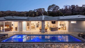 A modern house with a swimming pool, stone walls, and a large patio area. - Baymere Pool Spa City Views (Melbourne)