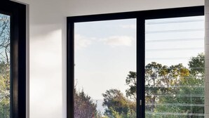 A modern room with a large window, a bench, and a chair. - Banksia Luxury Home With Views (Melbourne)