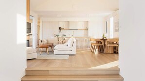 Un salon moderne comprenant un canapé, une table basse et un coin repas avec des chaises et une table.