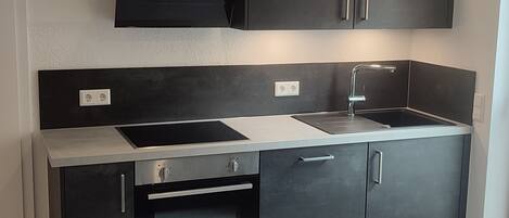 Een microgolfoven, een oven, een kookplaat, een vaatwasser