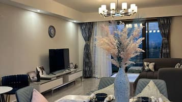 Family Apartment, City View | Living area | 32-inch Smart TV with digital channels