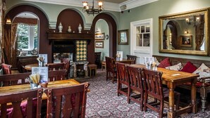 A traditional inn with wooden furniture, a patterned floor, and a fireplace. - Rambler Inn (Hope Valley)