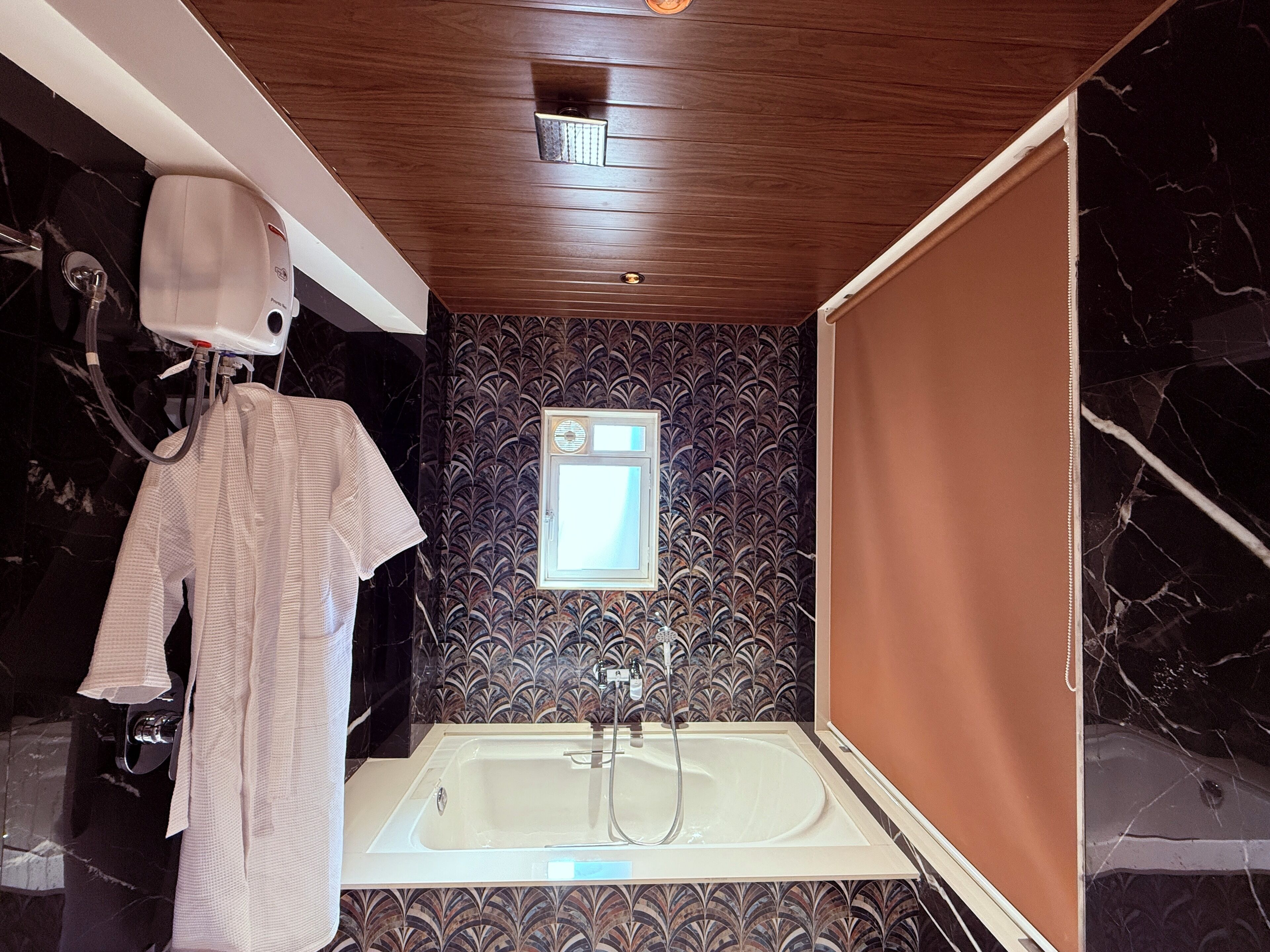 A bathroom with a bathtub, a towel rack, and a showerhead.