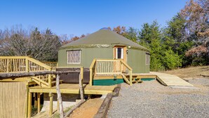 Eine Jurte mit Holzterrasse, einer Rampe und einer kleinen Veranda.
