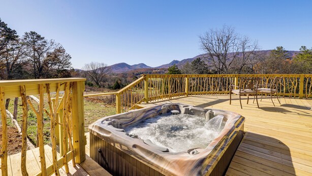 Ein Whirlpool auf einer Holzterrasse mit Bergblick.