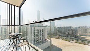 A high-rise building with a glass balcony, a table, and chairs. - Mins from City Walk, Downtown Dubai and Jumeirah Beach, Easy Access to Metro Stations (Dubai)