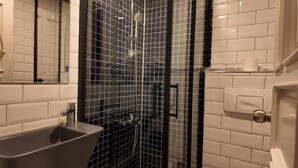 A bathroom with a glass shower enclosure, a sink, and a toilet. - Hotel Zurich Oldtown (Antalya)