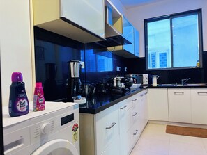 Una cocina moderna equipada con lavadora, cafetera y microondas.