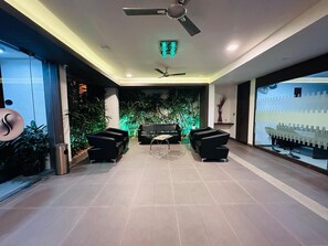 Un interior moderno con zona de estar, ventiladores de techo y vistas al mar.