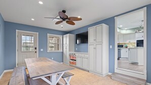A spacious kitchen with white cabinets, a large island, and a ceiling fan.