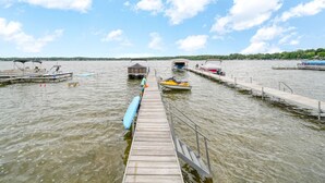 A wooden pier extending into a lake with boats docked at the end.