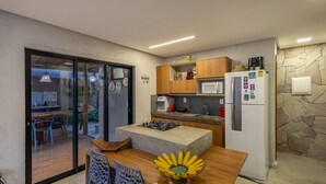 A modern kitchen with a built-in gas stove, a refrigerator, and wooden cabinets. - House w/ Pool 140m From the Beach Clb0002 (São Miguel dos Milagres)