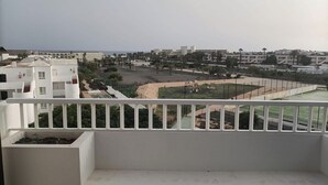 A balcony with a view of a residential area, including buildings and a sports field. - The Balcony of the 4 Moons - Apartment 631 (Costa Teguise)