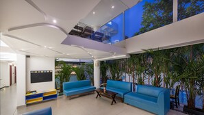 Un interior moderno con sofás azules, una mesa de centro de madera y un gran ventanal con vistas a zonas verdes.