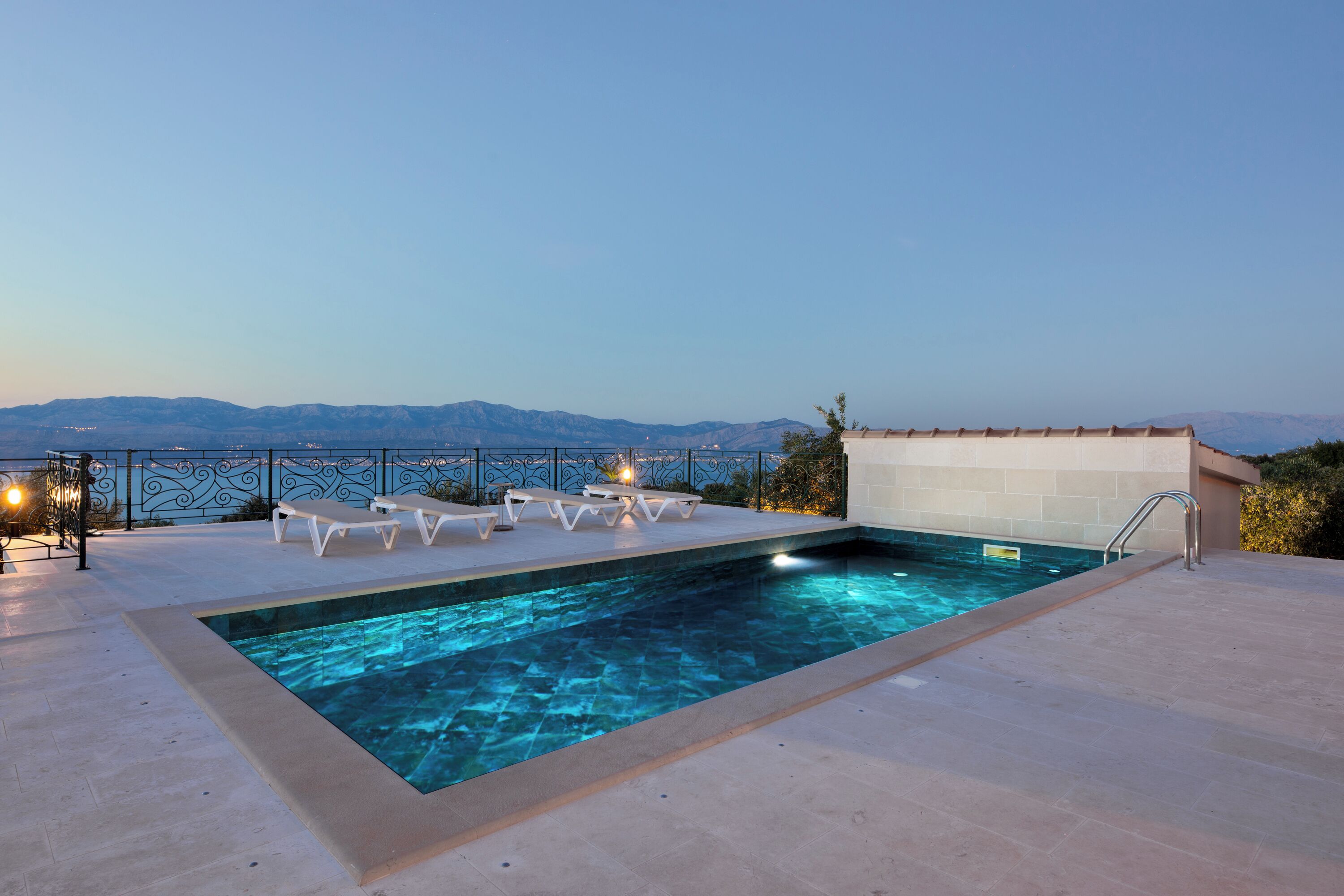 Une piscine sur le toit, dotée de chaises longues et offrant une vue sur les montagnes.