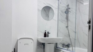 Ένα σύγχρονο μπάνιο με τουαλέτα, νιπτήρα και ντους.