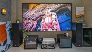 A large flat-screen TV mounted on a wall, flanked by two black speakers and a small table with a plant. - Xiuhu Lodge (Jiaoxi)