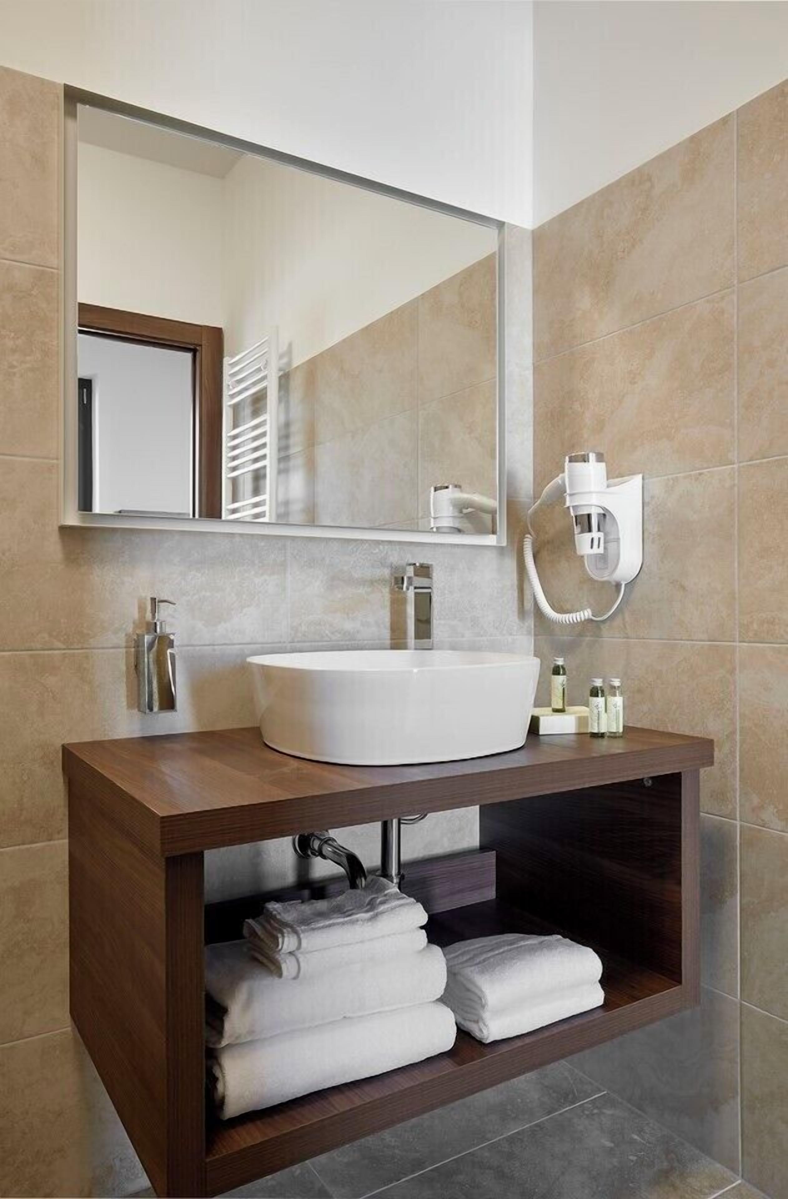 Chuveiro, secador de cabelo, chinelos, toalhas de banho