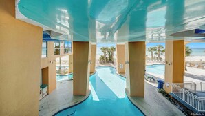 Un espace piscine offrant une vue dégagée sur la plage et les palmiers.