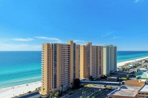 A high-rise hotel with multiple floors, a beach view, and a parking area. - NEW Listing! FREE Daily Golf&Perks! Splash W502 w/Hot Tub & Heated Pool &Gym! (Panama City Beach)