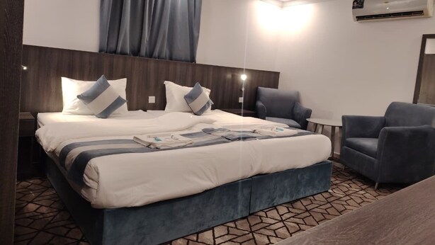 Een moderne hotelkamer met een groot bed, een bureau en een stoel.