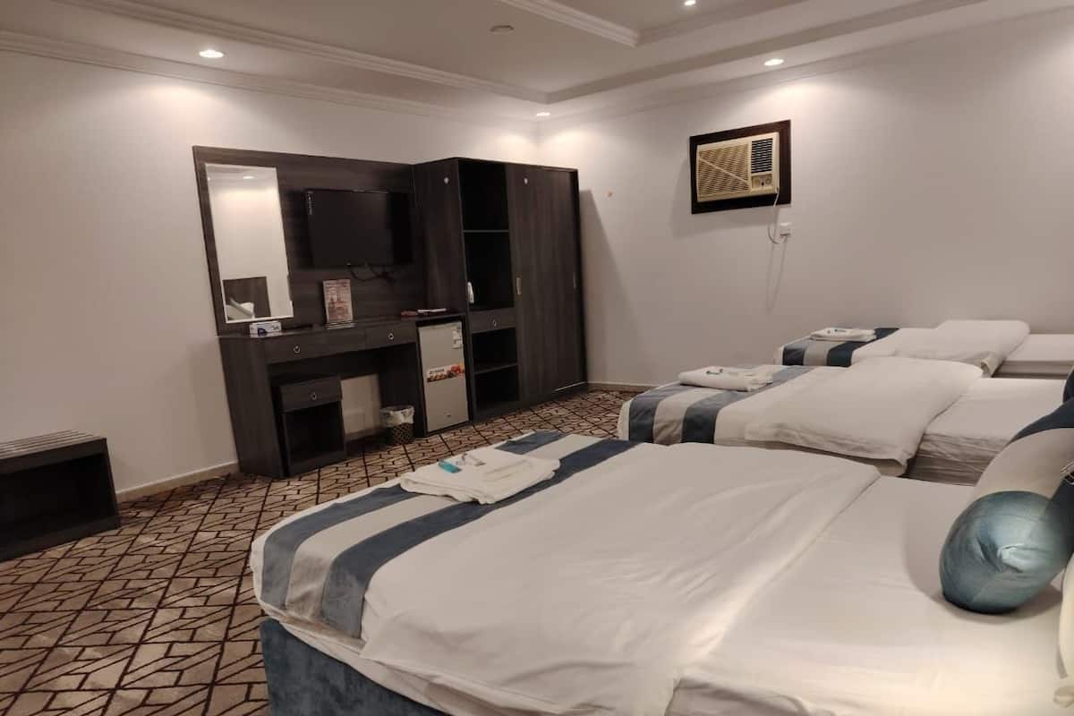 Een hotelkamer met een groot bed, een kledingkast, een spiegel en een televisie.