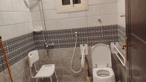 Een badkamer met toilet, douche, handdroger en een dweil.
