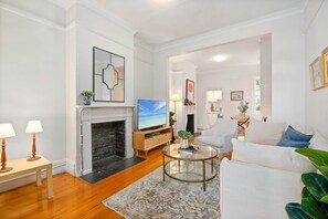 A modern living room with a fireplace, a television, and a comfortable seating area. - Stylish 2-bed House With Private Courtyard (Sydney)