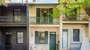 A row of townhouses with balconies, a front door, and a mailbox. - Stylish 2-bed House With Private Courtyard (Sydney)