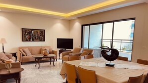 Uma sala de estar moderna com sofá, mesa de centro e área de jantar.