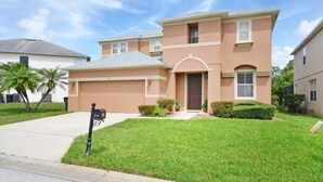 A two-story house with a garage, a front yard with a mailbox, and a well-maintained lawn. - Willow View 4 Bedroom Home (Davenport)