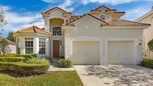 A two-story house with a garage, a covered porch, and a well-maintained lawn. - Ohana Haven 5 Bedroom Home (Kissimmee)