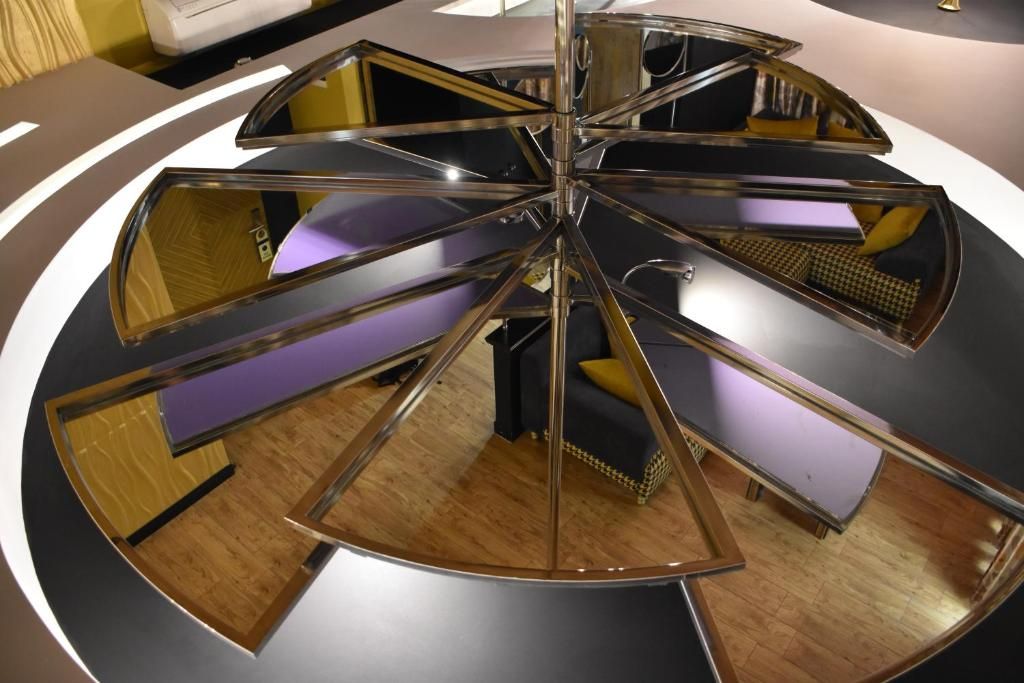 A circular, multi-level structure with reflective surfaces and a central column.