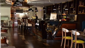 A modern bar area with a wooden floor, bar stools, and a counter with a digital display. - Tirana Room Rentals (Tirana)