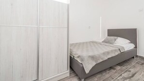 Un dormitorio con una cama, un armario y una ventana.